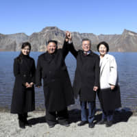 South Korean President Moon Jae-in (second from right) and his wife, Kim Jung-sook (right), stand with North Korean leader Kim Jong Un and his wife, Ri Sol Ju, on Mount Paektu in North Korea on Sept. 20. | POOL / VIA AP