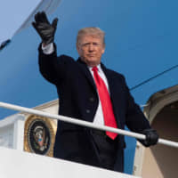 U.S. President Donald Trump waves as he prepares to board Air Force One at Andrews Air Force Base in Maryland on Saturday. | AFP-JIJI