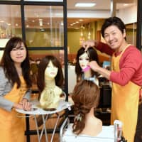 Fukuribi general manager Hitomi Iwaoka (left) and wig designer and director Katsuyuki Akagi pose for a picture at Appearance Support Center Tokyo in Bunkyo Ward last week. | SATOKO KAWASAKI