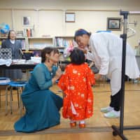 Volunteers from Ichigo Initiative apply makeup to a little girl who is preparing to take part in the shichi-go-san festival at Seibi Home in Tokyo. | ALEX MARTIN