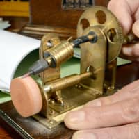 Junno Nakamura has developed a machine to sharpen turntable needles made of cactus spines. | CHUNICHI SHIMBUN