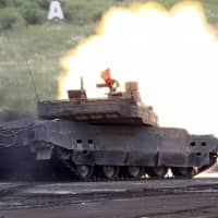 A Ground Self-Defense Force Type-10 tank fires its gun at a target during an annual live-firing exercise at Higashi-Fuji training range in Gotemba, Shizuoka Prefecture, in August 2016. | AP