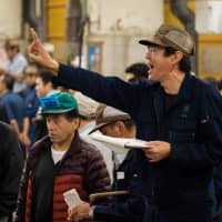 An auctioneer yells during the final tuna auction at the landmark Tsukiji fish market on its last day of operations before it closed for relocation. | AFP-JIJI