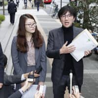 Lim Jae-sung (right), a lawyer representing South Korean plaintiffs in a court case over labor during World War II, speaks to reporters on Nov. 12 in front of the Nippon Steel &amp; Sumitomo Metal Corp. headquarters in Tokyo. | KYODO