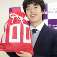 Professional shogi player Sota Fujii poses after winning his 100th official match Wednesday in Tokyo. | KYODO