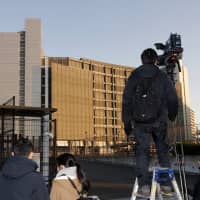 TV crews stand in front of the Tokyo Detention Center, where former Nissan Chairman Carlos Ghosn and another former executive, Greg Kelly, are being detained, in Tokyo on Friday. | AP
