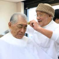 Tasuku Honjo, who won the 2018 Nobel Prize in physiology or medicine, gets a haircut in the city of Kyoto on Sunday. | KYODO