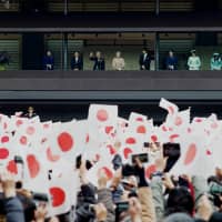 People wave Hinomaru flags as they celebrate Emperor Akihito\'s 85th birthday while being greeted by members of the Imperial family at the Imperial Palace in Tokyo on Sunday. It was the last official birthday ceremony held for the Emperor, who plans to abdicate on April 30. | RYUSEI TAKAHASHI