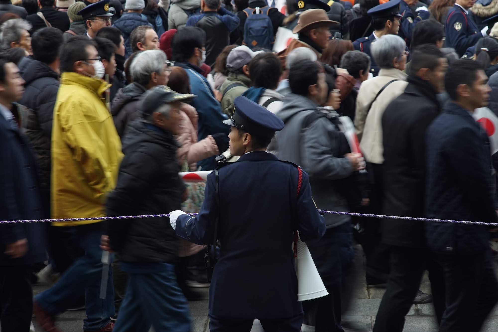 Police usher crowds to the Imperial Palace grounds on Sunday.