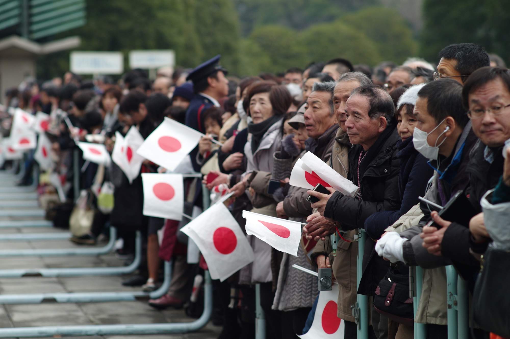 People wait to catch a glimpse of Emperor Akihito on his 85th birthday.