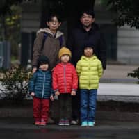 Masahiro and Kiyoko Higuchi brought their three sons to the Emperor\'s birthday celebration on Sunday \"to witness history.\" | RYUSEI TAKAHASHI