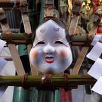 A rake featuring an okame (a mask with the appearance of a round-faced woman) from the Edo Period is displayed at Shinichi Kawabata\'s stall at the Otori Shrine in Asakusa on Nov. 25. | CHISATO TANAKA