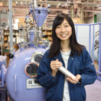 Yukiko Ogawa, 28, stands next to the induction melting furnace in her lab at the National Institute for Materials Science in Tsukuba, Ibaraki Prefecture.  | NATIONAL INSTITUTE FOR MATERIALS SCIENCE