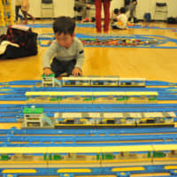 A child plays with battery-powered plastic trains on a giant track laid out at Purafesu, an event held at the Plaza North culture center in the city of Saitama on Saturday. | ANDREW MCKIRDY
