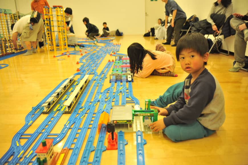 Children play with Plarail, a railway construction kit produced by toy-maker Takara Tomy, at Purafesu on Saturday.