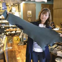 Makiko Kumagai holds a piece of sharkskin, which is used in products she sells at her store in Kesennuma, Miyagi Prefecture. | KYODO