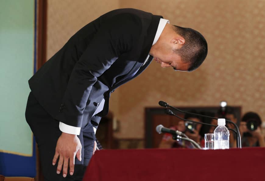 Nihon University defensive end Taisuke Miyagawa bows deeply on May 22 at the Japan National Press Club, where he apologized for an illegal tackle and revealed he was forced to make the controversial play by his coach, Masato Uchida.