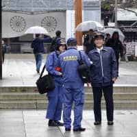 Officials from the Fire and Disaster Management Agency inspect Yasukuni Shrine in Chiyoda Ward, Tokyo, on Dec. 12, following a small fire incident due to a protest. | KYODO