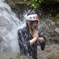 Taking the plunge: A young women practices misogi, or ritual purification at the Shirataki Daimyojin waterfall. | STEPHEN MANSFIELD