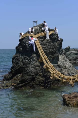 Hanging out: Teams of volunteers change the shimenawa (sacred rope) of Meoto Iwa in Mie Prefecture.