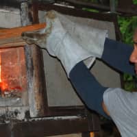 Satake tends the kiln of his studio. | COURTESY OF AKIRA SATAKE