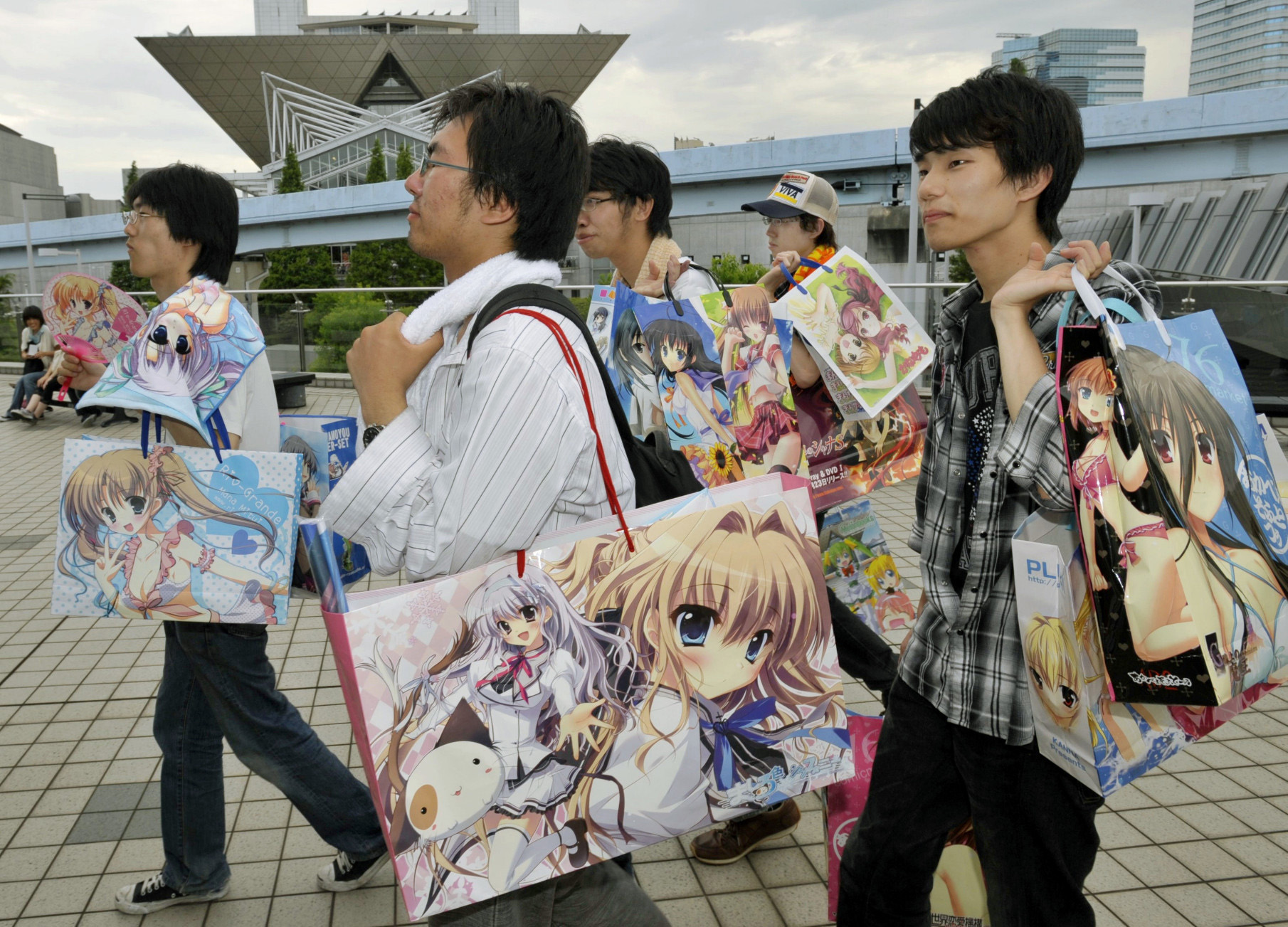 Participants in the Comic Market are seen carrying paper bags bearing images of various characters in animated films and games at the Tokyo Big Sight on Aug. 14, 2009. | KYODO
