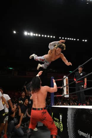 Wrestler Hiroshi Tanahashi dives on top of Jay White during a New Japan Pro-Wrestling event at Tokyo
