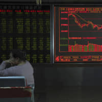 A board in Beijing shows falling stock prices Thursday after the arrest of Huawei\'s CFO. | AP