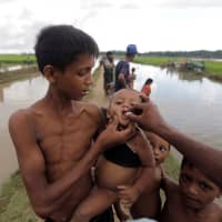 Rohingya refugees who crossed into Bangladesh the previous day from Myanmar receive cholera vaccines while they await permission to continue to refugee camps on Oct. 17, 2017. | REUTERS