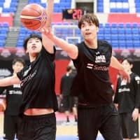 Akatsuki Five forward Joji Takeuchi (right) shoots a layup against Tenketsu Harimoto during the team\'s practice in Toyama on Sunday night. | KAZ NAGATSUKA