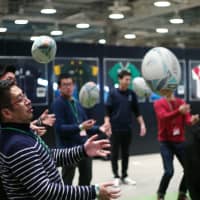 An applicant for the 2019 Rugby World Cup\'s volunteer program catches a rugby ball during an interview session in Tokyo on Monday. RYUSEI TAKAHASHI | RYUSEI TAKAHASHI