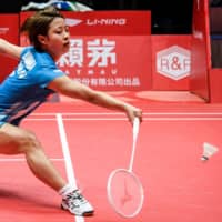 Nozomi Okuhara hits a return against Akane Yamaguchi in the women\'s semifinals at the BWF World Tour Finals in Guangzhou, China, on Saturday. | AFP-JIJI