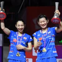Misaki Matsutomo (left) and Ayaka Takahashi celebrate after winning the badminton World Tour Finals championship in women\'s doubles on Sunday in Guangzhou, China. | KYODO