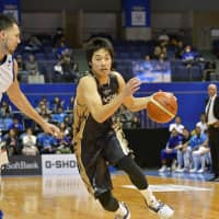 Mikawa\'s Yuta Okada dribbles the ball in the fourth quarter as Fukuoka\'s Blake Aoki defends on Friday night in Kariya, Aichi Prefecture. | B. LEAGUE