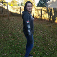 Nicole Zarate poses in her special order Yuzuru Hanyu sweatshirt in the backyard of her home in Raleigh, North Carolina. Courtesy of Nicole Zarate | COURTESY OF NICOLE ZARATE