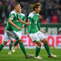 Bremen forward Yuya Osako (right) celebrates with teammates after scoring his team\'s first goal against Bayern on Saturday in Bremen, Germany. | AFP-JIJI