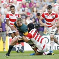 Kensuke Hatakeyama (3) tackles a South African player during their match at the 2015 Rugby World Cup on Sept. 19, 2015, in Brighton, England. | KYODO