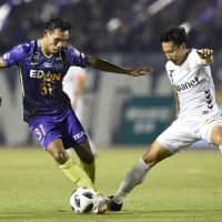 Sanfrecce striker Teerasil (left) tries to dribble past Nagasaki\'s Yusuke Maeda during an Aug. 11 match at Edion Stadium in Hiroshima. The Thai international will leave Sanfrecce following the conclusion of his year-long loan from Muangthong United. | KYODO