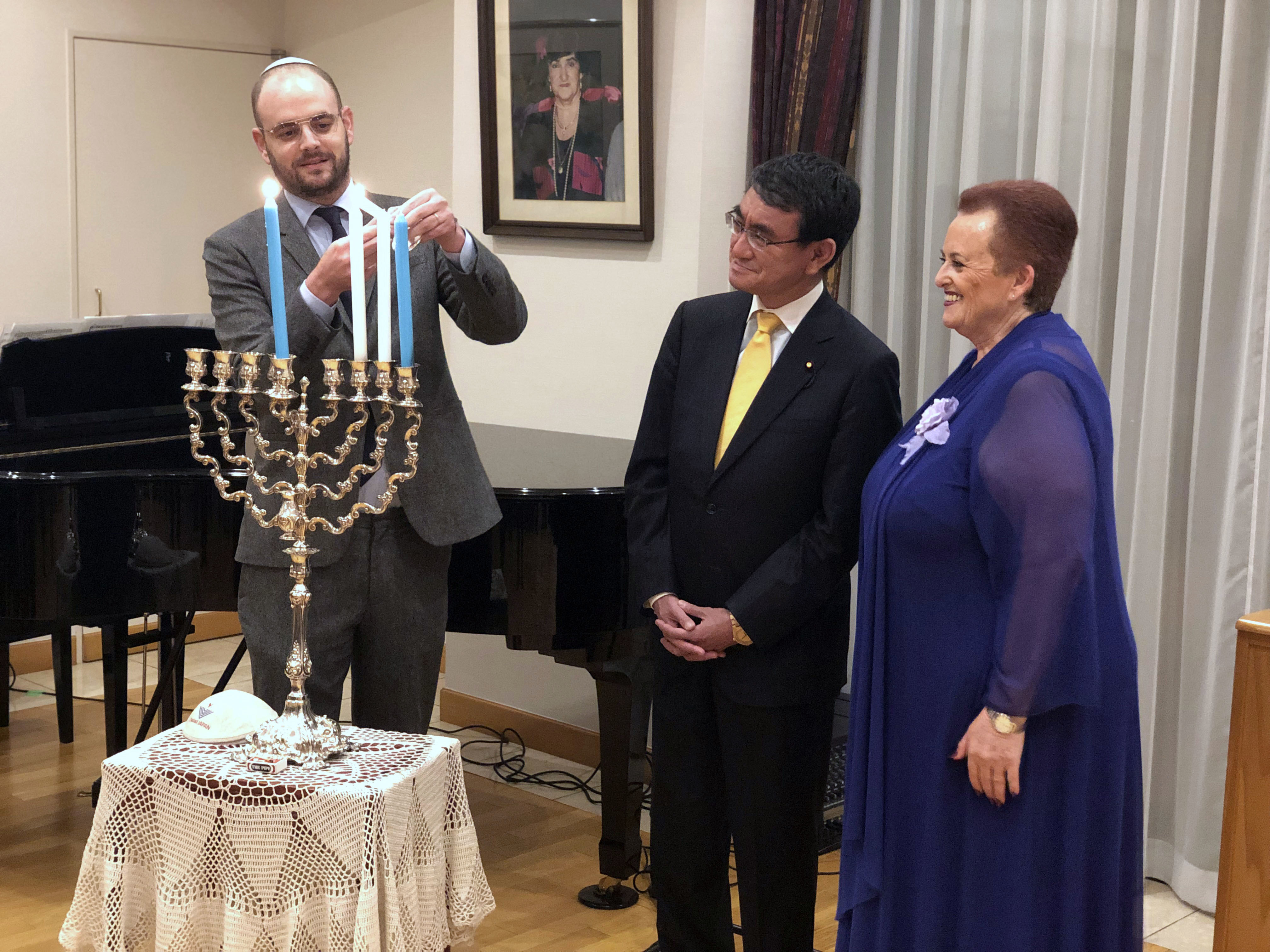 Foreign Minister Taro Kono (center) joins Israelian Ambassador Yaffa Ben-Ari (right) at a special Hanukkah candle lighting reception hosted at the Israeli ambassador's residence on Dec. 4. |   COURTESY OF THE EMBASSY OF ISRAEL