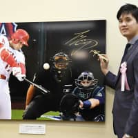 Los Angeles Angels star Shohei Ohtani poses for the cameras Tuesday after signing a photograph at an annual press photo exhibition in Tokyo. The exhibition, organized by the Tokyo Press Photographers Association, is being held at Mitsukoshi\'s flagship department store in the capital\'s Nihonbashi district and will run through Monday. | KYODO