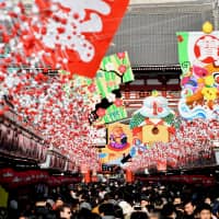 People fill the Nakamise-dori shopping strip leading to Sensoji temple in the Asakusa district of Tokyo on Tuesday, where a giant ema, a traditional Shinto plaque, with an illustration of wild boar &#8212; next year\'s Chinese zodiac sign &#8212; is displayed. | YOSHIAKI MIURA