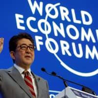Prime Minister Shinzo Abe speaks at the World Economic Forum Annual Meeting in Davos, Switzerland, on Wednesday. | REUTERS