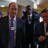 Larry Fink (left), chairman and chief executive officer of BlackRock Financial Management Inc., and Jose Vinals, chairman of Standard Chartered PLC, walk through the Congress Center on day three of the World Economic Forum (WEF) in Davos, Switzerland, on Thursday. | BLOOMBERG