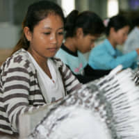 Women work at a Japanese plant in Cambodia. | KYODO