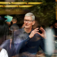 Apple CEO Tim Cook visits an Apple store in Shanghai last October. | REUTERS