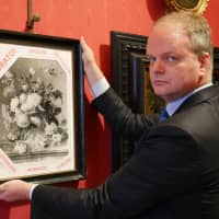 A handout picture realeased by the Florence Museum Press Office on Tuesday shows the Florence Uffizi Galleries director Eike Schmidt posing with a copy of the \"Vase of Flowers\" by Dutch painter Jan van Huysum, stolen from the Wehrmacht\'s Pitti Palace during World War II, in Florence, Italy. The Uffizi appealed to Berlin for help in retrieving the stolen 18th century Dutch painting from a German family. | FLORENCE MUSEUM PRESS OFFICE / VIA AFP-JIJI