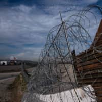 A border barrier along the Tijuana River is seen from Tijuana, Mexico, on Monday. | AFP-JIJI