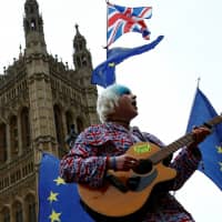 An anti-Brexit protester performs outside the Houses of Parliament after Prime Minister Theresa May\'s Brexit deal was rejected, in London Wednesday. | REUTERS