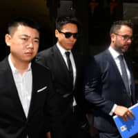 Chinese actor Gao Yunxiang (center) leaves the Downing Centre court in Sydney on Friday. | AAP /VIA REUTERS