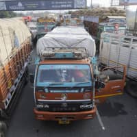 Trucks wait in line outside New Delhi after authorities stopped them from entering the city due to heavy pollution on Jan. 5. | AFP-JIJI